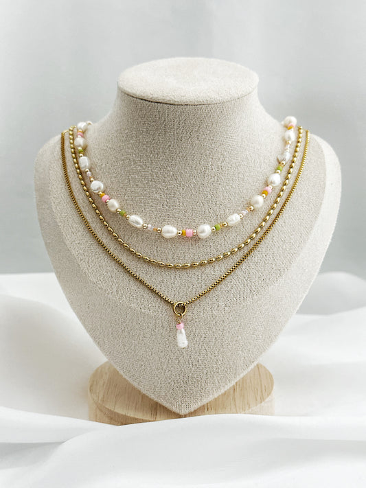 Dreiteiliges Layering-Kettenset mit goldenen Details, Süßwasserperlen und farbigen Akzenten auf Schmuckständer – wählbar in zwei Varianten.