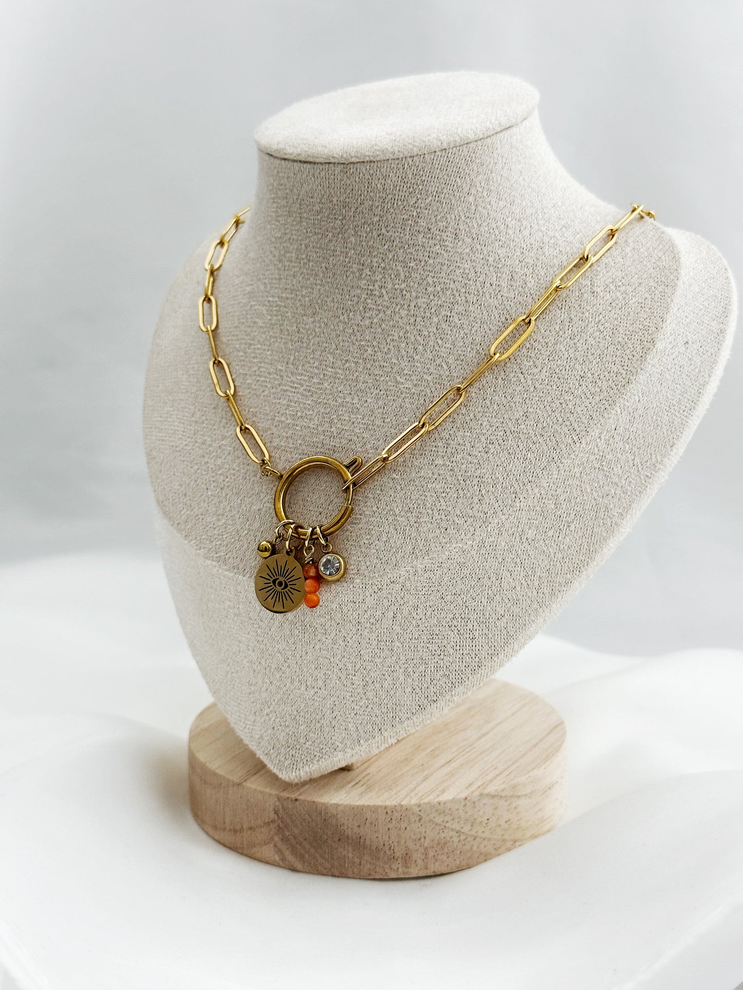 Goldene Edelstahl-Paperclip-Kette mit mittigem Karabiner und vier Anhängern: Kugel, Auge mit Sonnenstrahlen, orange Aventurin-Stack & weißer Stein