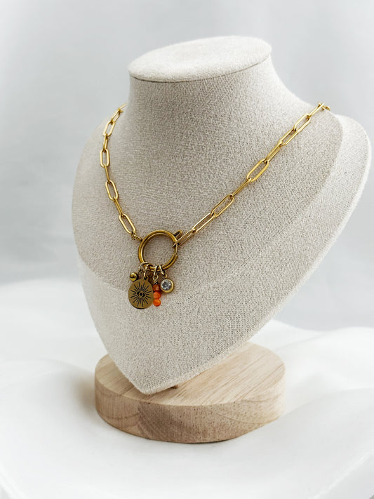 Goldene Edelstahl-Paperclip-Kette mit mittigem Karabiner und vier Anhängern: Kugel, Auge mit Sonnenstrahlen, orange Aventurin-Stack & weißer Stein