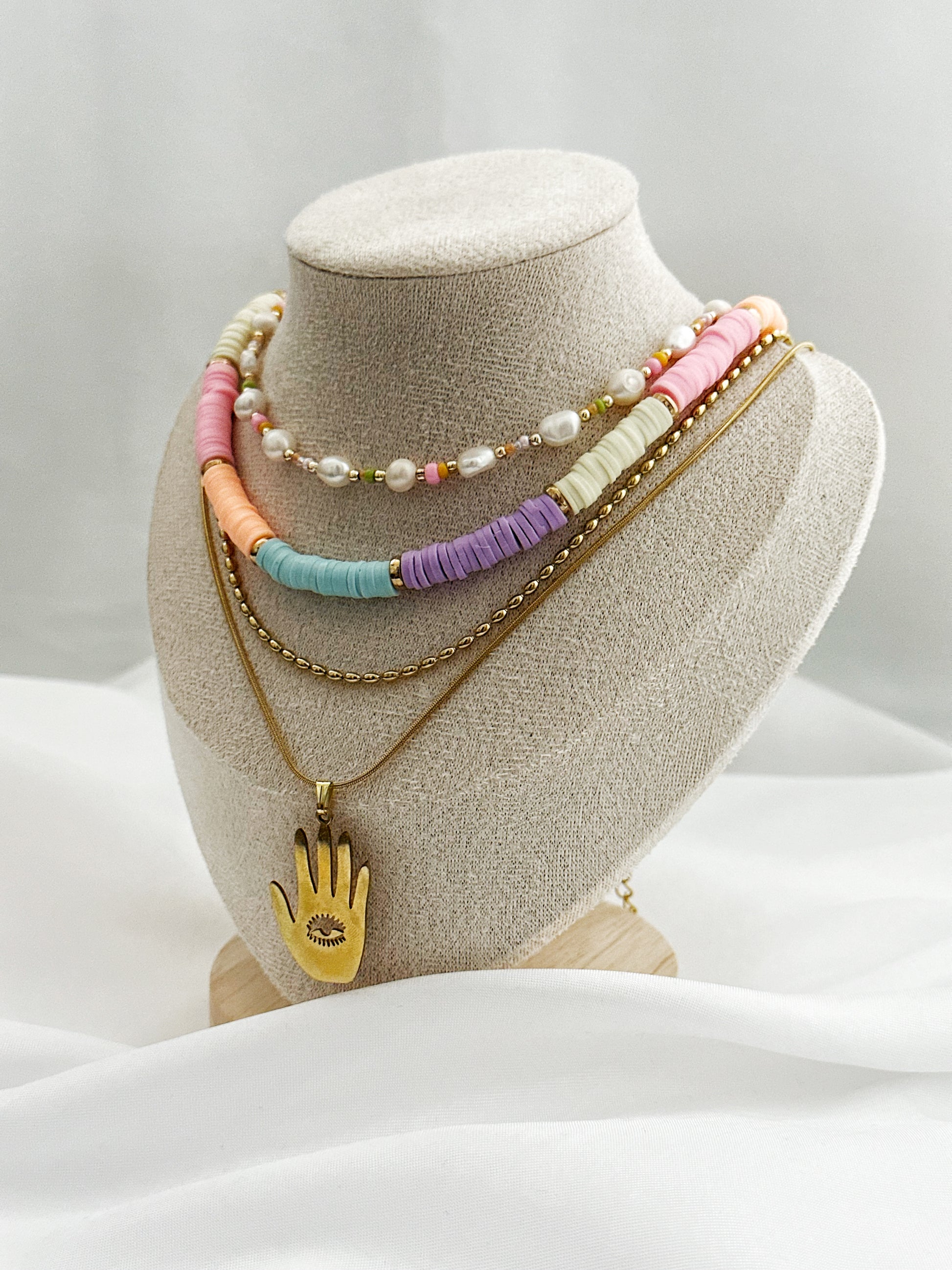 Layering-Schmuckset mit vier Halsketten bestehend aus Süßwasserperlen, bunten Fimo-Perlen, goldener Perlenkette und Hamsa-Anhänger in Gold
