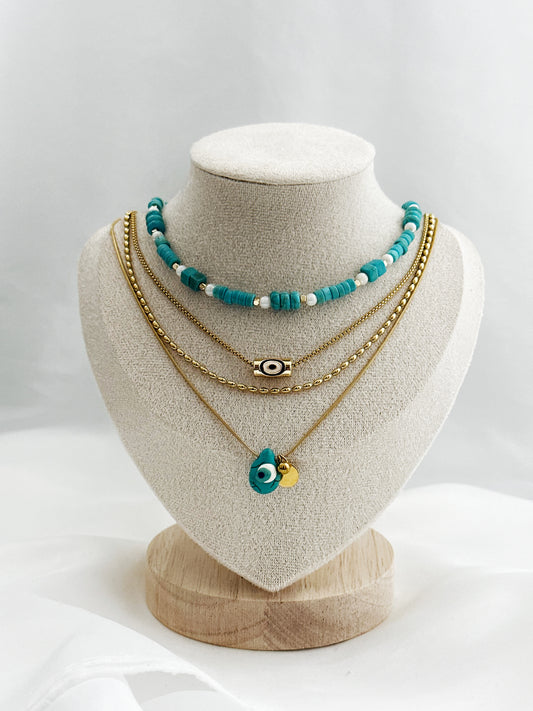 4-lagiges Layering-Kettenset auf hellem Untergrund – bestehend aus goldenen Edelstahlketten mit Nazar-Amuletten, echter Türkis- und Perlmuttkette im Boho-Stil