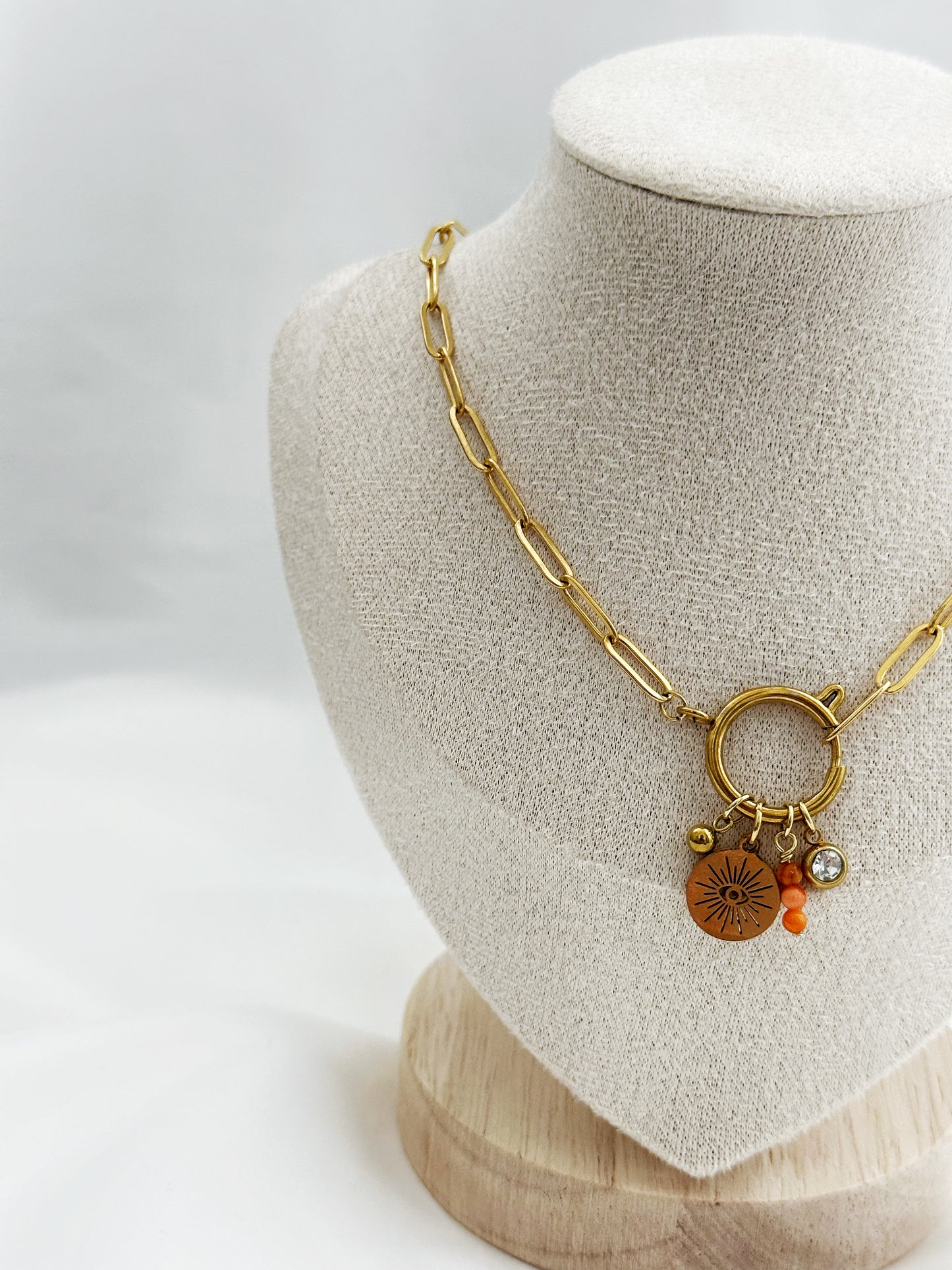 Goldene Edelstahl-Paperclip-Kette mit mittigem Karabiner und vier Anhängern: Kugel, Auge mit Sonnenstrahlen