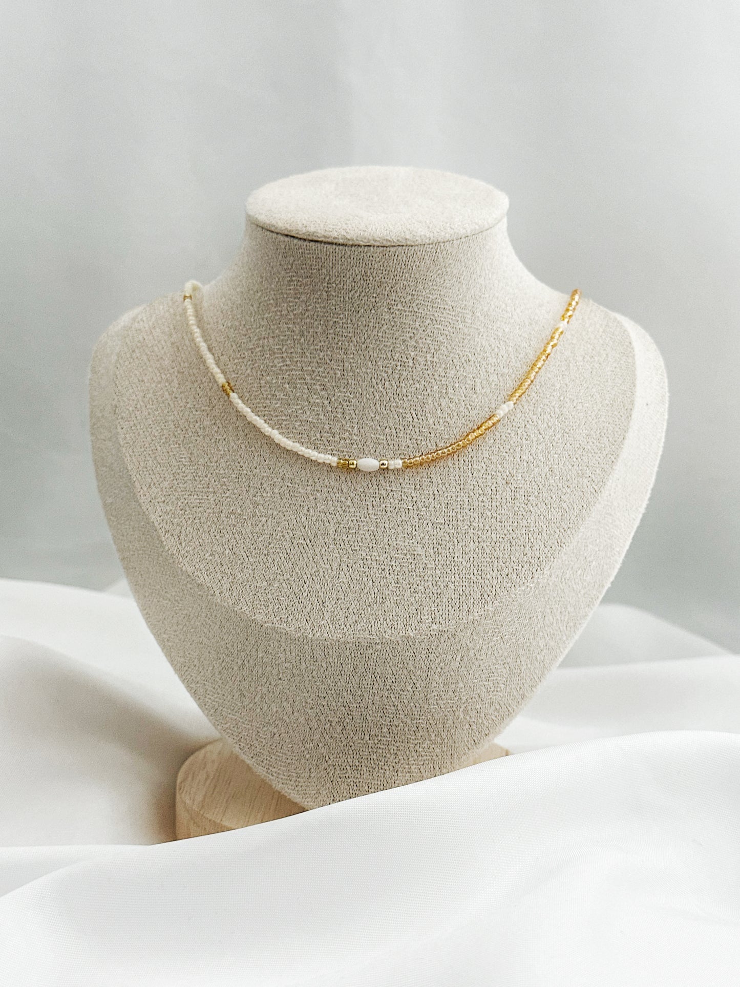 Zweifarbige Perlenkette in Weiß und Gold mit ovaler Perlmuttperle in der Mitte – 40 + 5 cm lang, filigraner Look